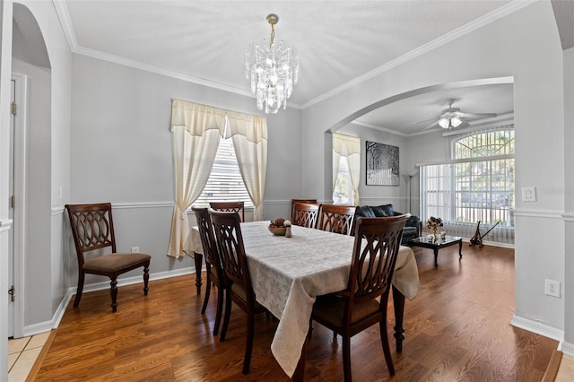 dining area featuring hardwood / wood-style floors, ceiling fan with notable chandelier, and ornamental molding