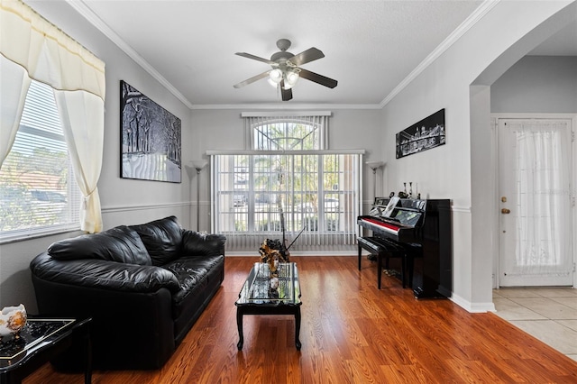 living room with crown molding, hardwood / wood-style floors, and ceiling fan