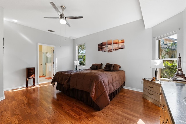 bedroom featuring hardwood / wood-style flooring, ceiling fan, and connected bathroom