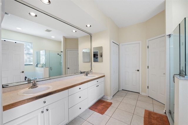 bathroom with tile patterned floors, vanity, and a shower with shower door