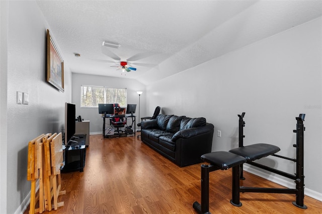 living room with a textured ceiling, ceiling fan, lofted ceiling, and hardwood / wood-style flooring