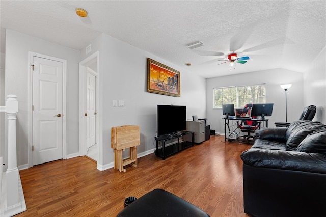 living room featuring hardwood / wood-style flooring, ceiling fan, lofted ceiling, and a textured ceiling