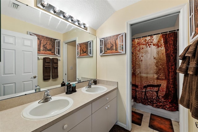 bathroom with vanity, vaulted ceiling, tile patterned flooring, a textured ceiling, and curtained shower