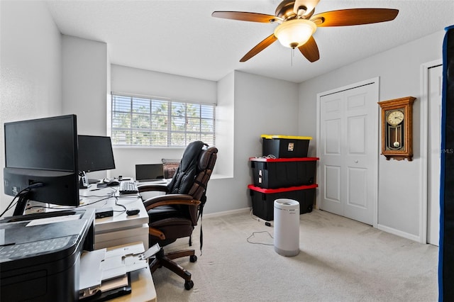 carpeted home office with a textured ceiling and ceiling fan