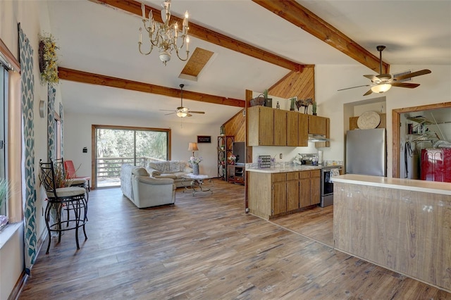 kitchen with stainless steel appliances, light countertops, brown cabinetry, open floor plan, and light wood-type flooring