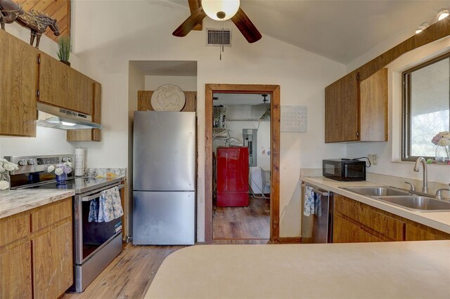 kitchen featuring stainless steel appliances, lofted ceiling, visible vents, a sink, and under cabinet range hood