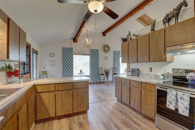 kitchen with vaulted ceiling with beams, a peninsula, under cabinet range hood, light countertops, and stainless steel range with electric stovetop