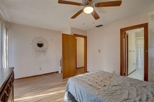 bedroom featuring baseboards, visible vents, ceiling fan, a textured ceiling, and light wood-type flooring