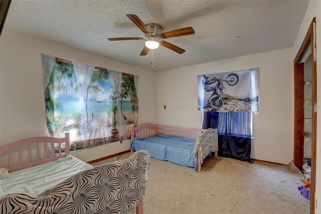 carpeted bedroom featuring a textured ceiling, ceiling fan, and baseboards