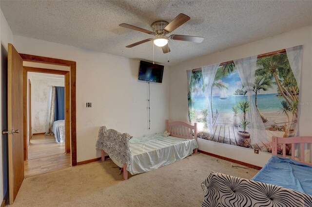 bedroom featuring a textured ceiling, ceiling fan, carpet, and baseboards