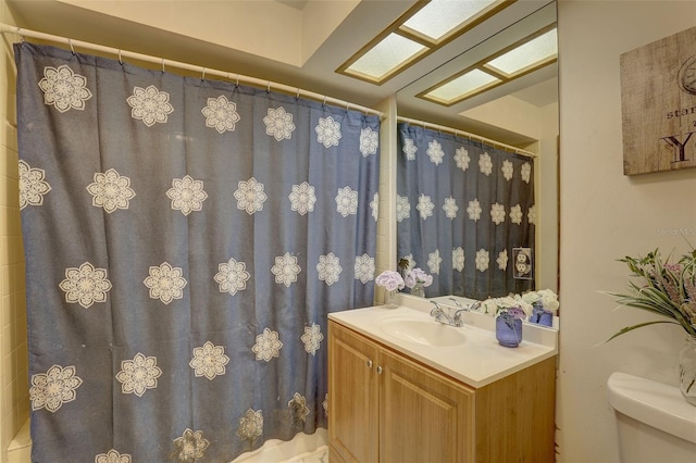 full bathroom featuring toilet, a skylight, and vanity