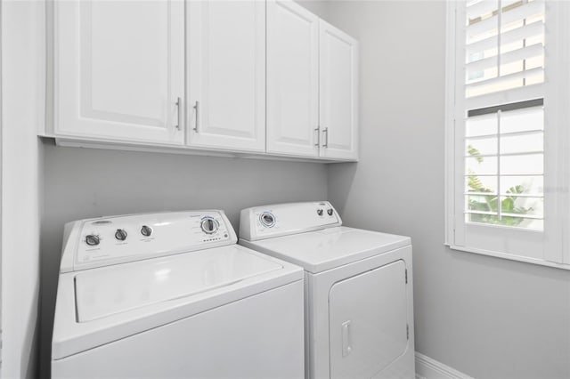 laundry room with washing machine and dryer and cabinets