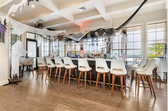 kitchen with beam ceiling, coffered ceiling, and hardwood / wood-style flooring