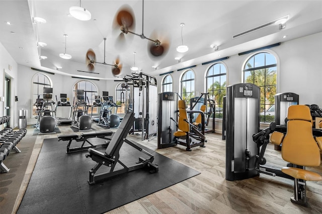 workout area with light wood-type flooring and ceiling fan