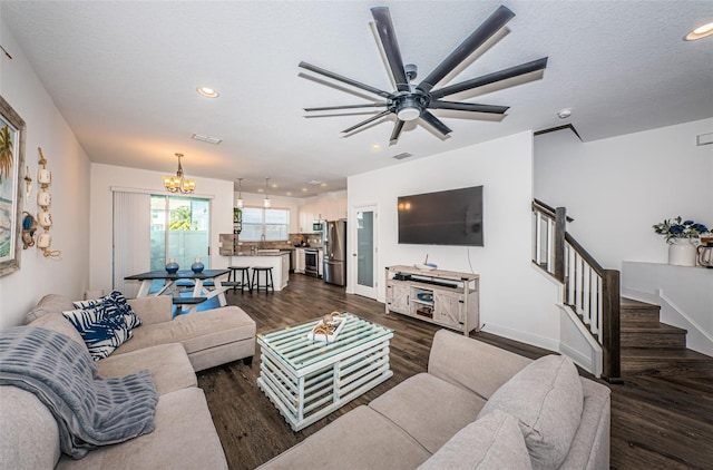 living room with sink, dark wood-type flooring, a textured ceiling, and ceiling fan with notable chandelier