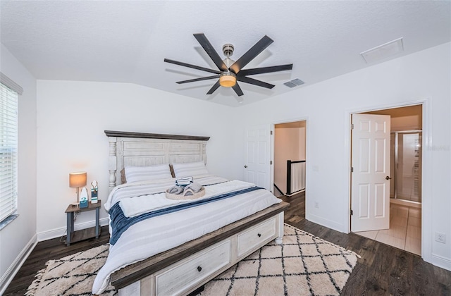 bedroom featuring lofted ceiling, hardwood / wood-style floors, ensuite bath, and ceiling fan