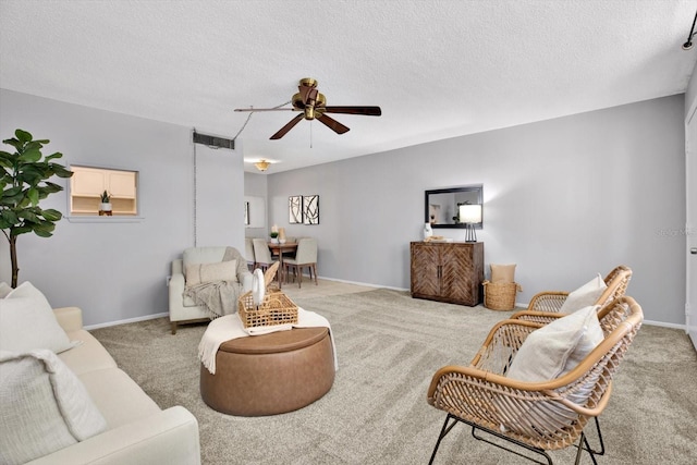 living room with ceiling fan, a textured ceiling, and carpet floors