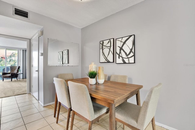 dining space featuring light tile patterned flooring and a textured ceiling