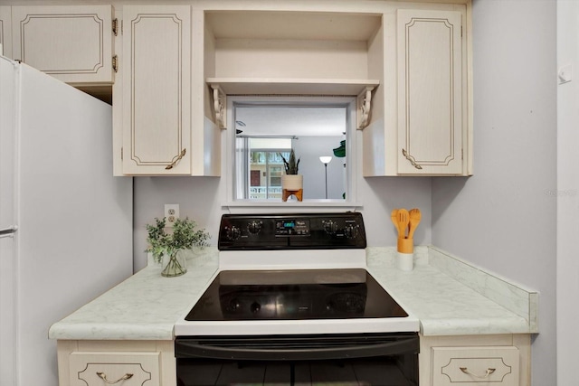 kitchen featuring cream cabinets and white appliances