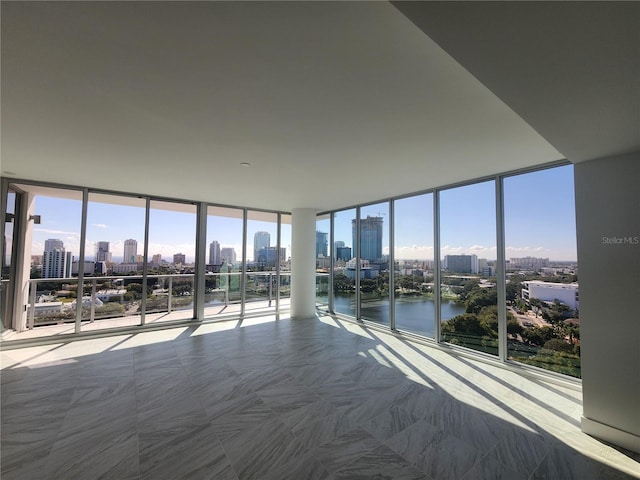 unfurnished bedroom with expansive windows and a water view