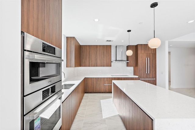 kitchen with wall chimney exhaust hood, hanging light fixtures, backsplash, a large island, and sink