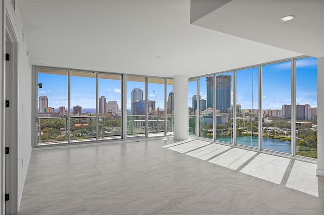 unfurnished room featuring a water view, a healthy amount of sunlight, and expansive windows