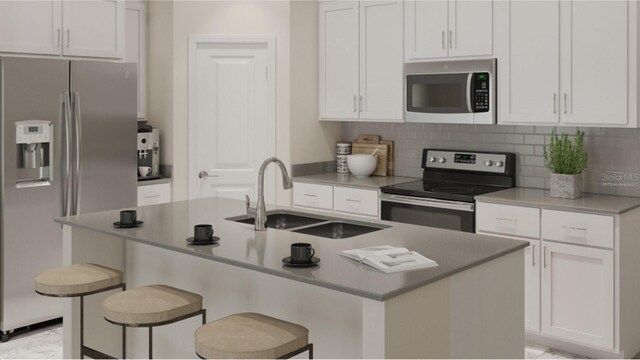 kitchen with white cabinetry, stainless steel appliances, and an island with sink