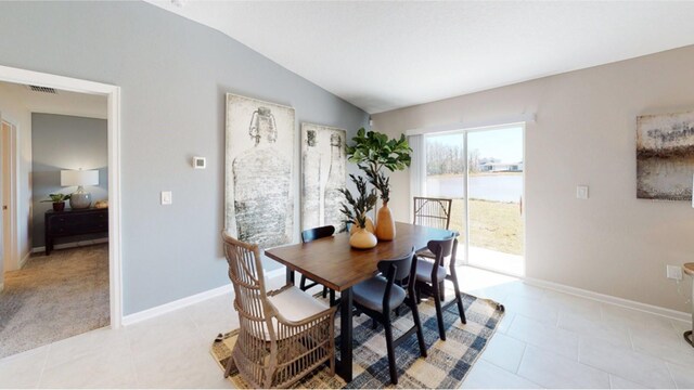 tiled dining space with vaulted ceiling