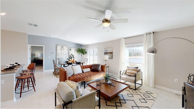 living room featuring lofted ceiling, light tile patterned floors, and ceiling fan