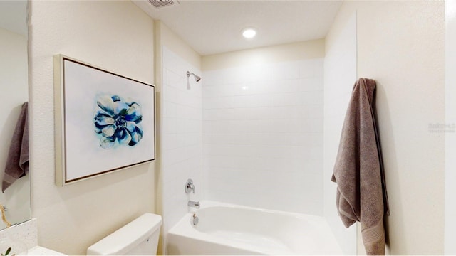 bathroom with toilet and tiled shower / bath combo