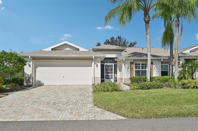 single story home with a garage and a front lawn