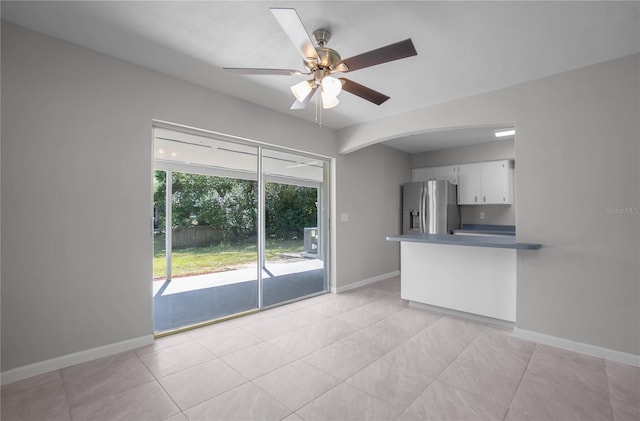 unfurnished living room featuring ceiling fan and light tile patterned floors