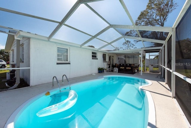 view of swimming pool with a patio area and a lanai