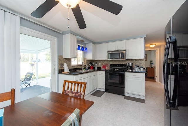 kitchen featuring sink, black appliances, white cabinetry, and tasteful backsplash