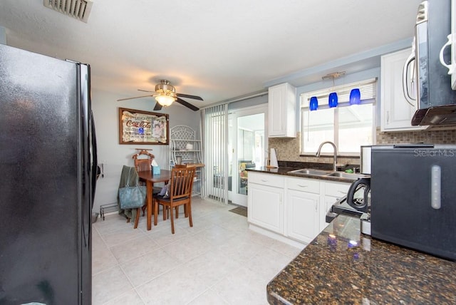 kitchen featuring sink, white cabinetry, fridge, and tasteful backsplash