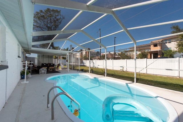 view of pool featuring a yard, a patio area, and glass enclosure