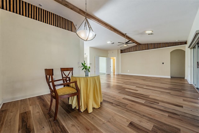 dining area with ceiling fan, lofted ceiling with beams, and wood-type flooring