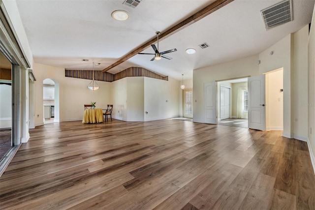 unfurnished living room with lofted ceiling with beams, hardwood / wood-style flooring, and ceiling fan