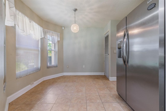 unfurnished dining area featuring light tile patterned flooring