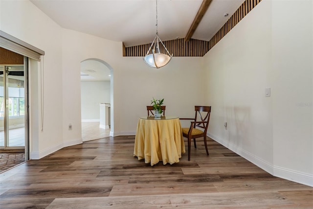 dining space with lofted ceiling with beams and wood-type flooring