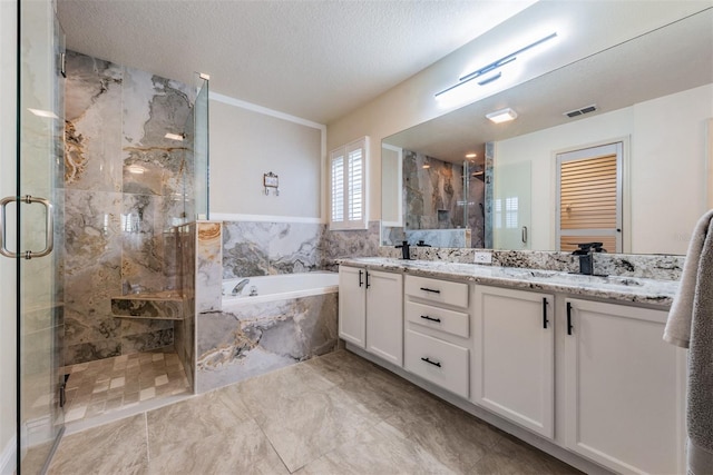 bathroom featuring vanity, a textured ceiling, and independent shower and bath