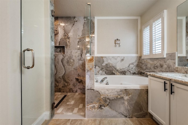 bathroom featuring vanity, a textured ceiling, and plus walk in shower