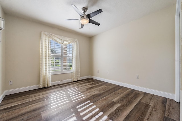 empty room with a textured ceiling, dark hardwood / wood-style floors, and ceiling fan