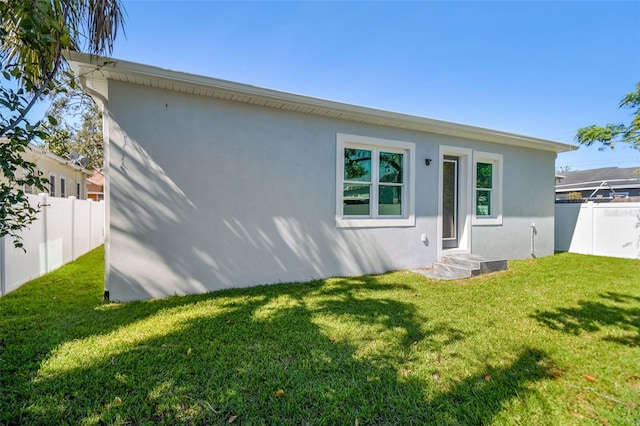 rear view of property featuring a yard