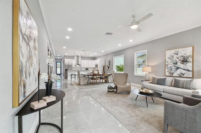 living room featuring ceiling fan and crown molding