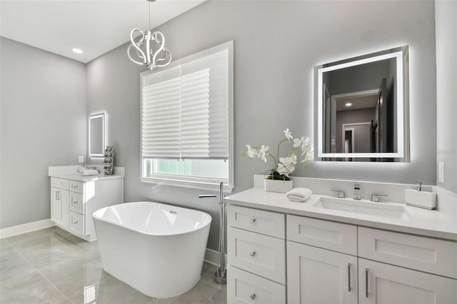 bathroom featuring a notable chandelier, vanity, and a tub