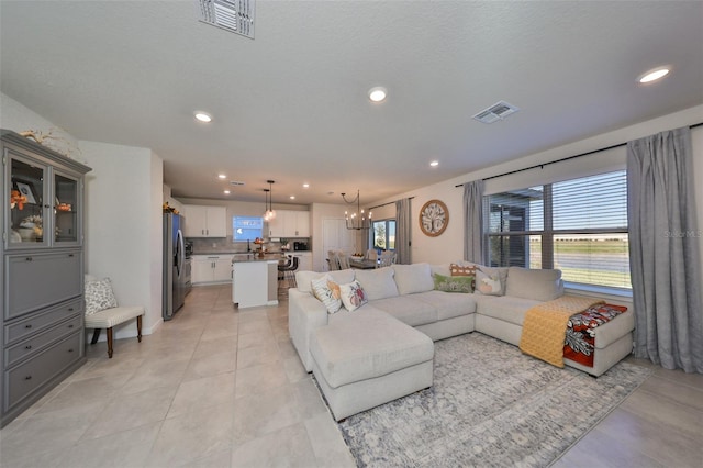 tiled living room with an inviting chandelier