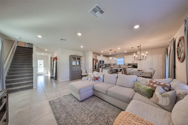 tiled living room with a notable chandelier