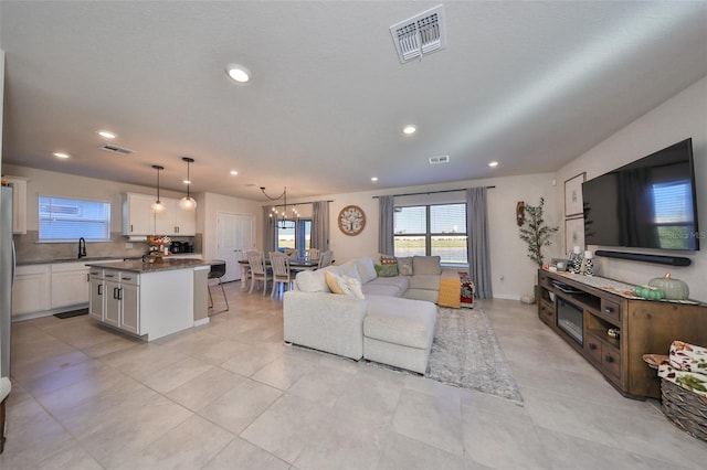 tiled living room with sink and a chandelier