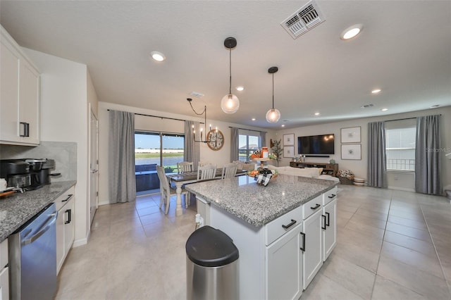 kitchen with light stone countertops, dishwasher, a center island, hanging light fixtures, and white cabinets